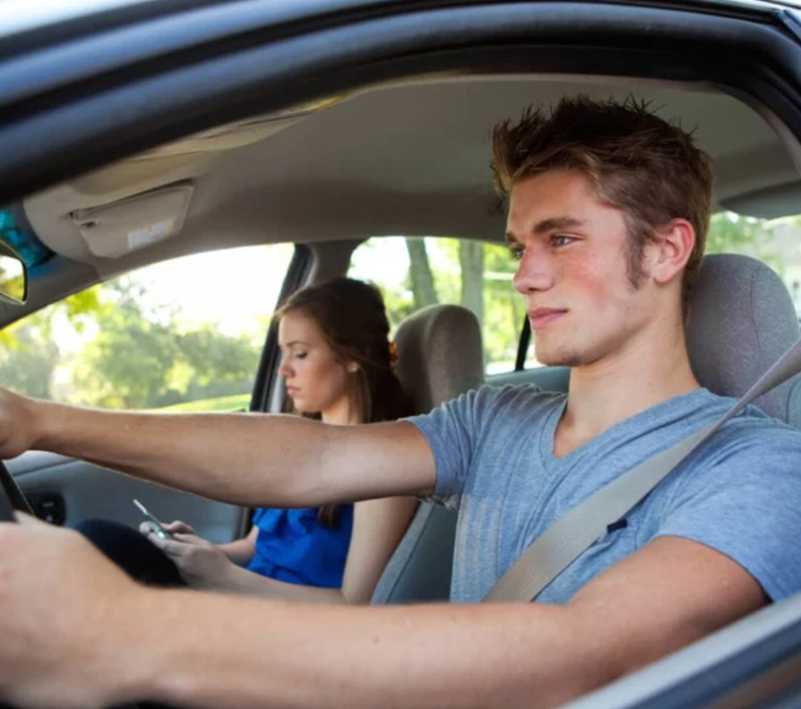 Two young adults head back to school in their car.