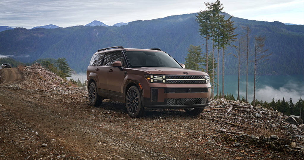 2024 Hyundai Santa Fe in the earthy brass matte color parked on an off road trail.