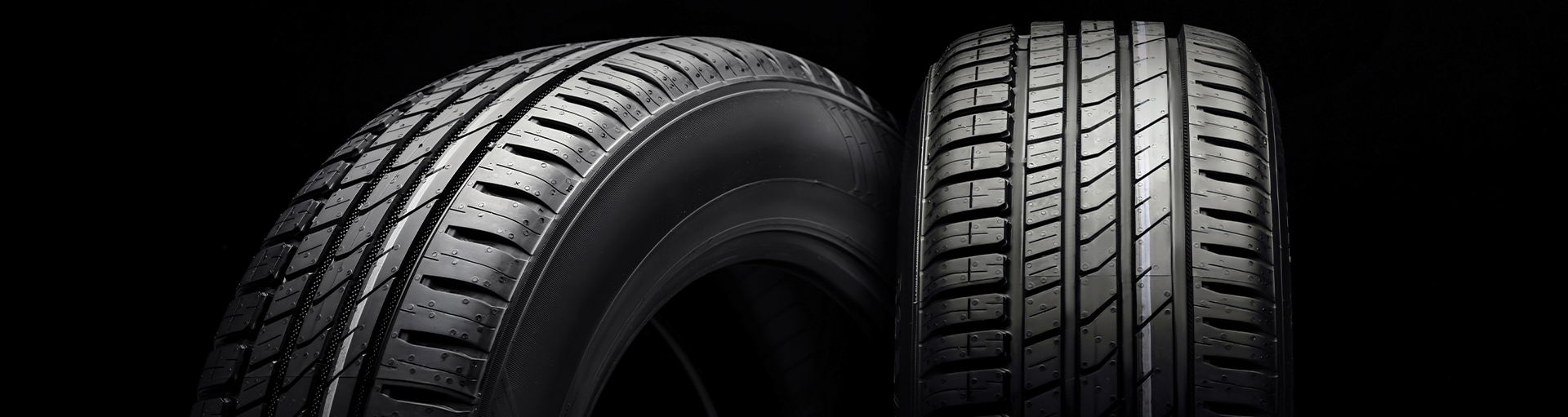 2 new car tires propped up on each other