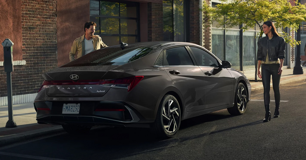 A dark grey Hyundai Elantra Hybrid parked on a city street.